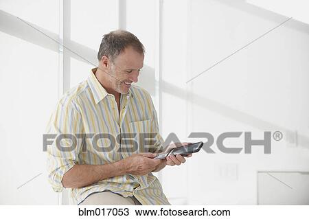 Stock Image - Caucasian man using tablet computer. Fotosearch