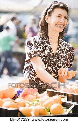Caucasian woman buying eggs at market View Large Photo Image Stock Photo - Caucasian woman buying eggs at market. Fotosearch