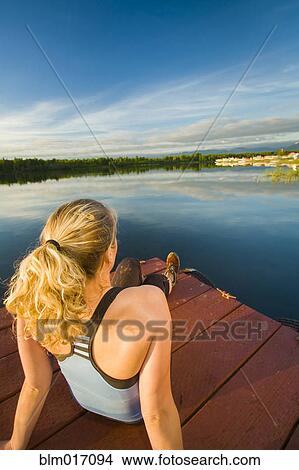 Caucasian woman relaxing on dock on still lake, Anchorage, Alaska, United States View Large Photo Image Picture - Caucasian woman relaxing on dock on still lake, Anchorage, Alaska, United States. Fotosearch