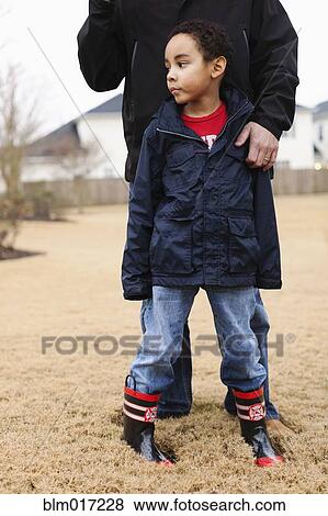Stock Photo - Father and son standing in field. Fotosearch
