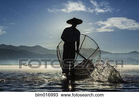 Fisherman rowing canoe on water View Large Photo Image Stock Image - Fisherman rowing canoe on water. Fotosearch