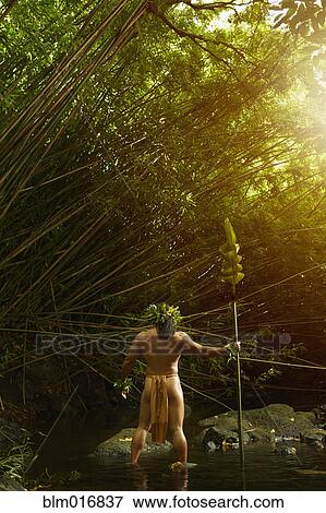 Stock Photo - Hawaiian man in traditional outfit spear fishing. Fotosearch