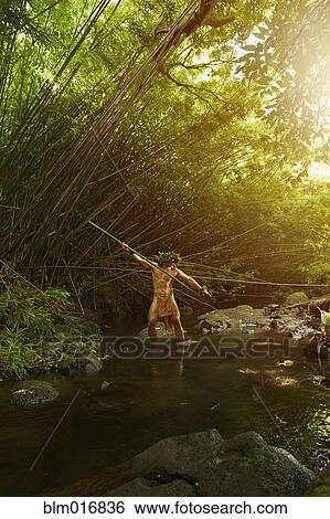 Stock Photograph - Hawaiian man in traditional outfit spear fishing. Fotosearch
