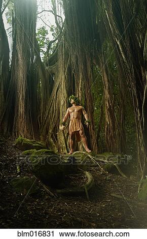 Stock Image - Hawaiian man wearing traditional outfit in jungle. Fotosearch