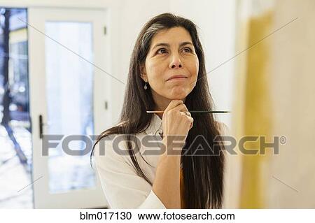 Stock Image - Hispanic artist working in studio. Fotosearch