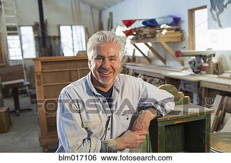 Stock Photograph - Hispanic craftsman smiling in studio. Fotosearch