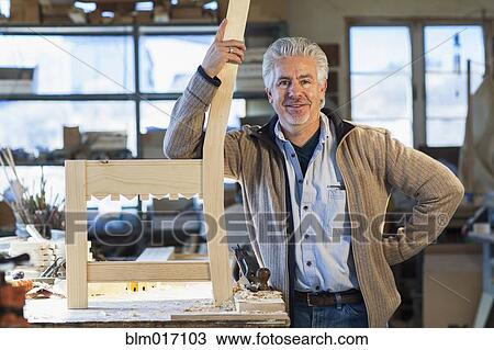 Stock Image - Hispanic craftsman standing in studio. Fotosearch