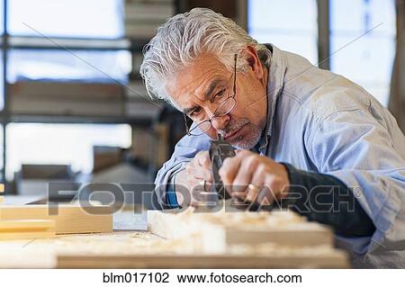 Stock Image - Hispanic craftsman working in studio. Fotosearch