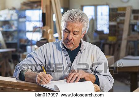Stock Photo - Hispanic craftsman working in studio. Fotosearch