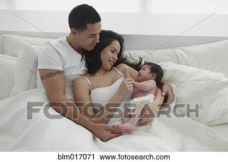 Hispanic family relaxing in bed View Large Photo Image Stock Image - Hispanic family relaxing in bed. Fotosearch