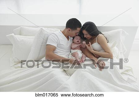 Hispanic family relaxing in bed View Large Photo Image Stock Photography - Hispanic family relaxing in bed. Fotosearch