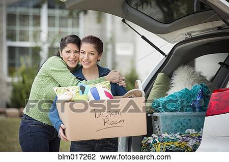 Stock Image - Hispanic mother helping daughter pack for college. Fotosearch