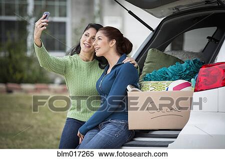 Stock Photography - Hispanic mother taking picture with daughter. Fotosearch