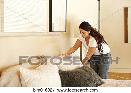 Hispanic woman making bed View Large Photo Image Stock Photo - Hispanic woman making bed. Fotosearch
