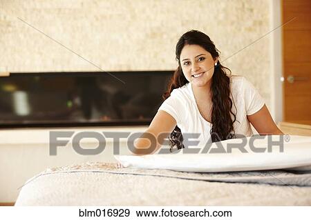 Hispanic woman making bed View Large Photo Image Stock Photo - Hispanic woman making bed. Fotosearch