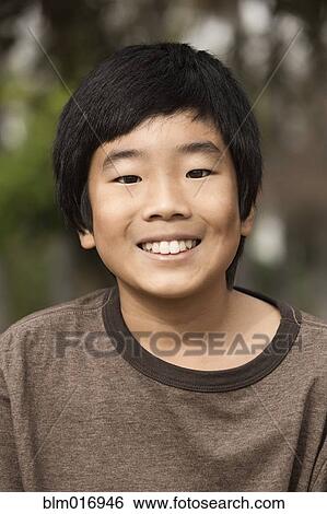 Stock Photograph - Korean boy smiling outdoors. Fotosearch