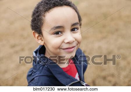 Stock Image - Mixed race boy smiling. Fotosearch