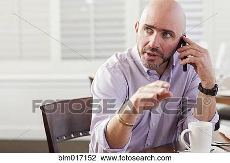 Stock Image - Mixed race businessman talking on cell phone. Fotosearch