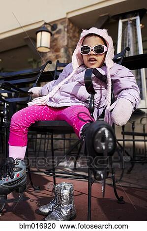 Stock Image - Mixed race girl wearing ice skates outdoors. Fotosearch