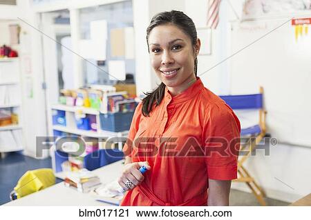 Mixed race teacher smiling in classroom View Large Photo Image Stock Image - Mixed race teacher smiling in classroom. Fotosearch