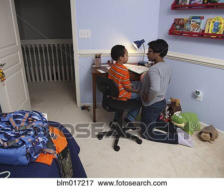 Stock Photo - Mother helping son with homework. Fotosearch