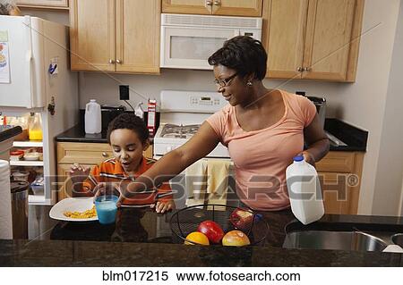 Stock Photography - Mother making lunch for son in kitchen. Fotosearch