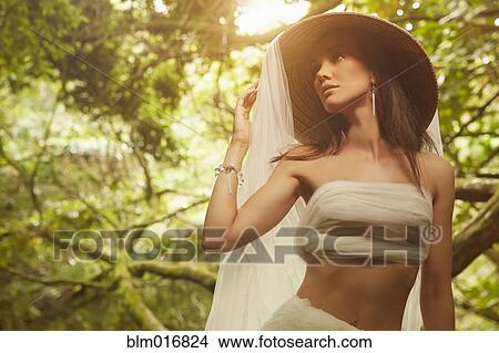 Picture - Pacific Islander woman wrapped in sheet in jungle. Fotosearch