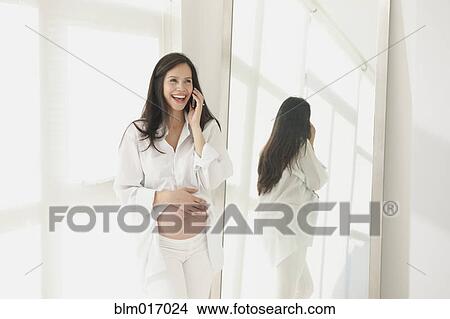Pregnant Hispanic woman talking on cell phone View Large Photo Image Picture - Pregnant Hispanic woman talking on cell phone. Fotosearch