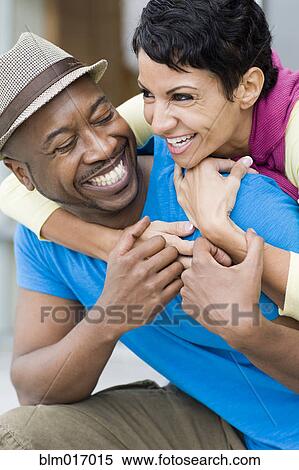 Stock Photography - Smiling couple hugging outdoors. Fotosearch