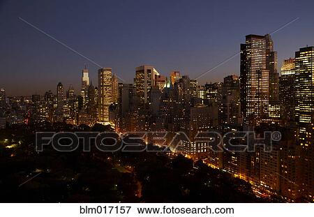 Stock Photo - Sunset and illuminated cityscape, New York, New York, United States. Fotosearch
