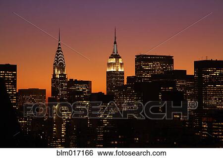 Stock Photograph - Sunset and illuminated cityscape, New York, New York, United States. Fotosearch