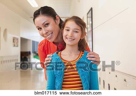 Teacher hugging student in school hallway View Large Photo Image Stock Photography - Teacher hugging student in school hallway. Fotosearch