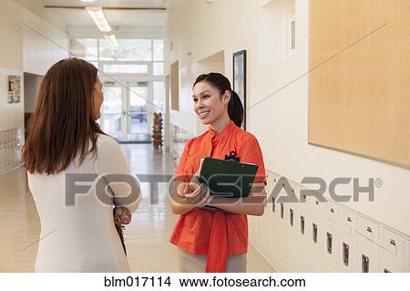 Picture - Teachers talking in school hallway. Fotosearch