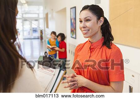 Teachers talking in school hallway View Large Photo Image Stock Image - Teachers talking in school hallway. Fotosearch