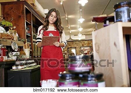 Stock Image - Woman working in grocery store. Fotosearch