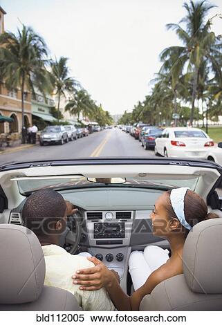 Stock Photography - African American couple driving in convertible. Fotosearch