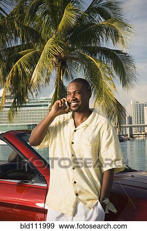 African American man talking on cell phone by car View Large Photo Image Stock Photo - African American man talking on cell phone by car. Fotosearch