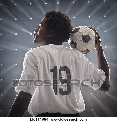 Black soccer player holding ball View Large Photo Image Picture - Black soccer player holding ball. Fotosearch