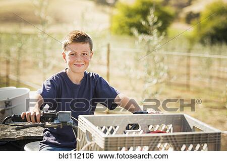 Stock Photograph - Caucasian boy driving four wheeler outdoors. Fotosearch