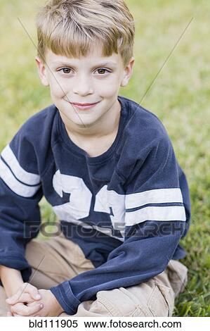 Stock Photography - Caucasian boy smiling on lawn. Fotosearch