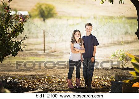 Stock Image - Caucasian children smiling in olive grove. Fotosearch