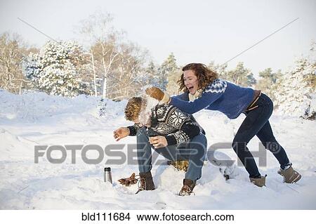 Picture - Caucasian couple playing in snow. Fotosearch