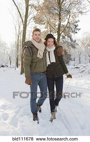 Caucasian couple pulling sled in snow View Large Photo Image Stock Photo - Caucasian couple pulling sled in snow. Fotosearch