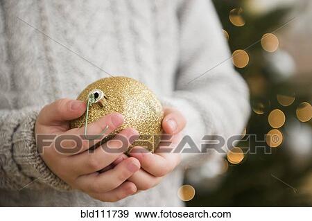 Stock Photo - Caucasian girl holding Christmas ornament. Fotosearch