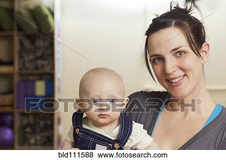 Caucasian mother holding baby in yoga studio View Large Photo Image Stock Photo - Caucasian mother holding baby in yoga studio. Fotosearch