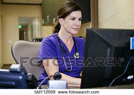 Caucasian nurse using computer in office View Large Photo Image Stock Photo - Caucasian nurse using computer in office. Fotosearch