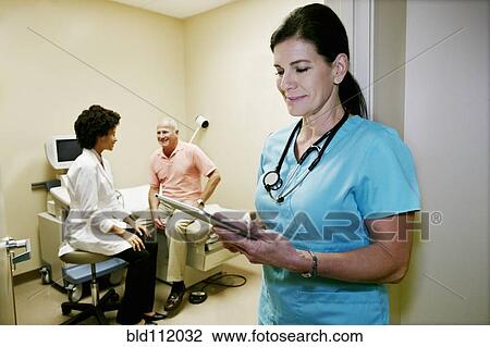 Stock Image - Caucasian nurse using digital tablet. Fotosearch