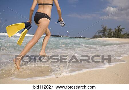 Caucasian woman carrying scuba equipment to water View Large Photo Image Stock Photo - Caucasian woman carrying scuba equipment to water. Fotosearch