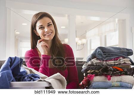 Stock Photo - Caucasian woman folding laundry. Fotosearch