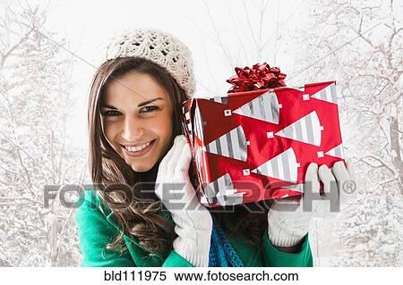 Caucasian woman holding Christmas gift in snow View Large Photo Image Stock Photography - Caucasian woman holding Christmas gift in snow. Fotosearch
